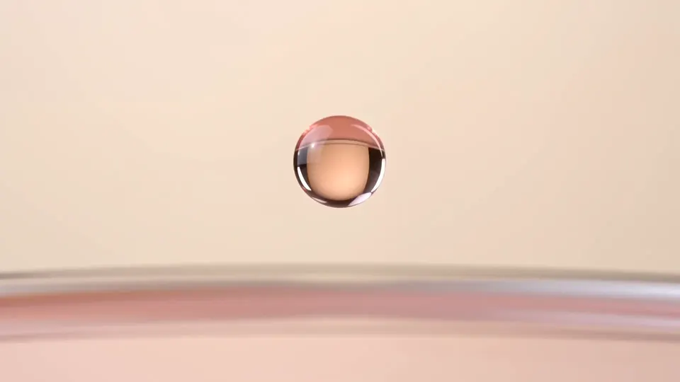 La Goutte, פריים 10: טיפת סרום ורודה תלויה באוויר מעל נוזל ורוד חלבי